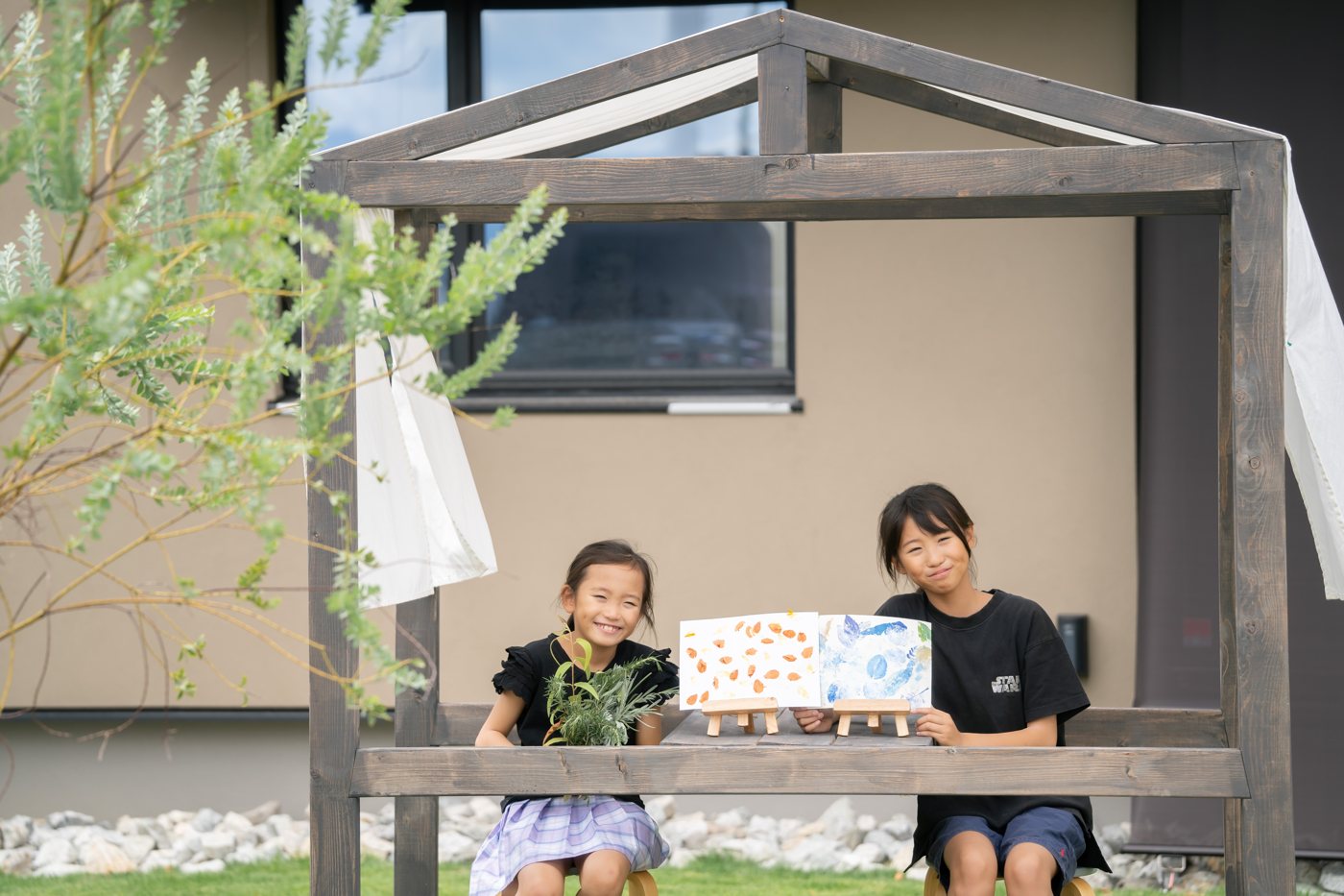 庭で作品を手にする子どもたち
