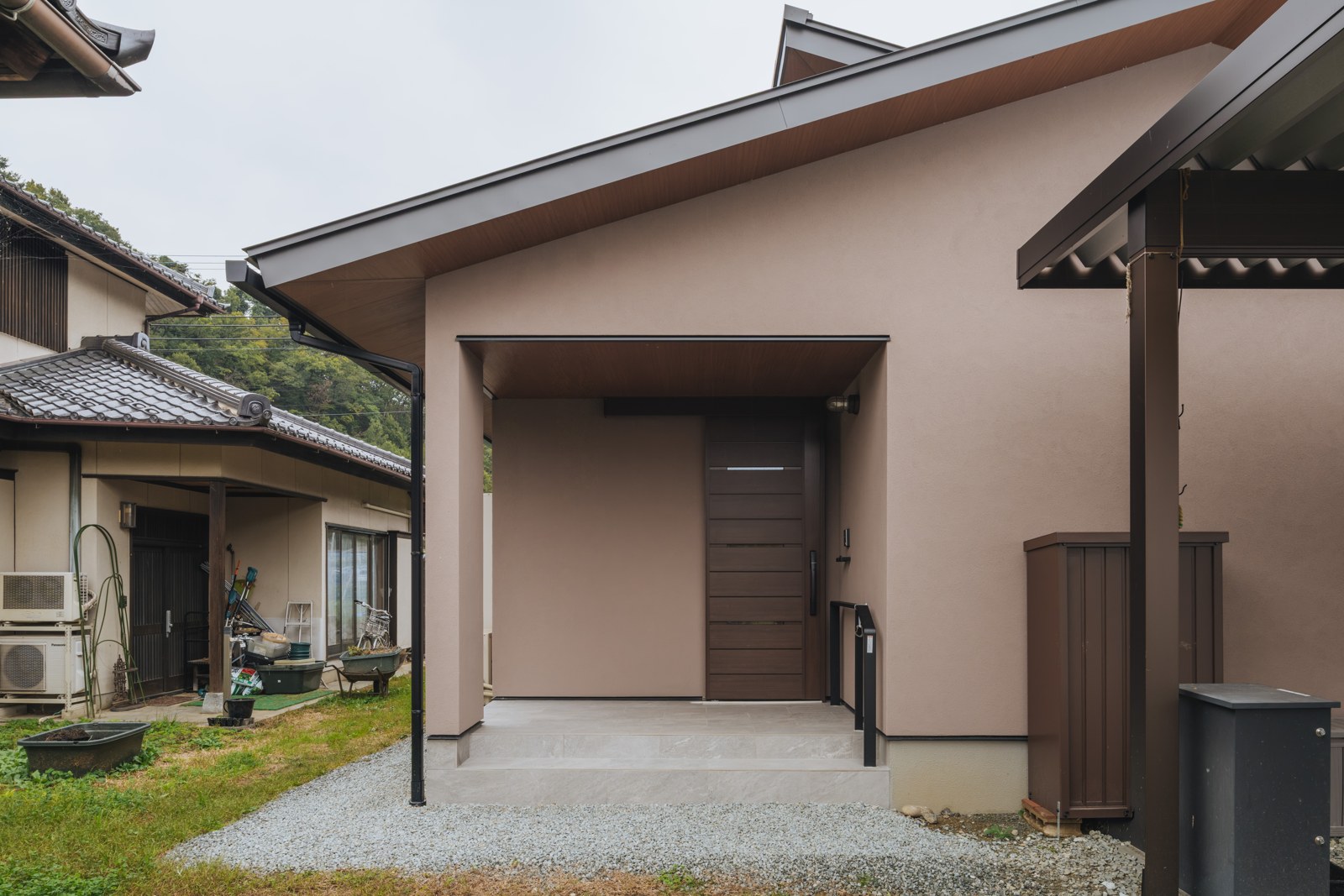 外観に合わせたウォルナット色の玄関ドアは引き戸にして 使いやすく。